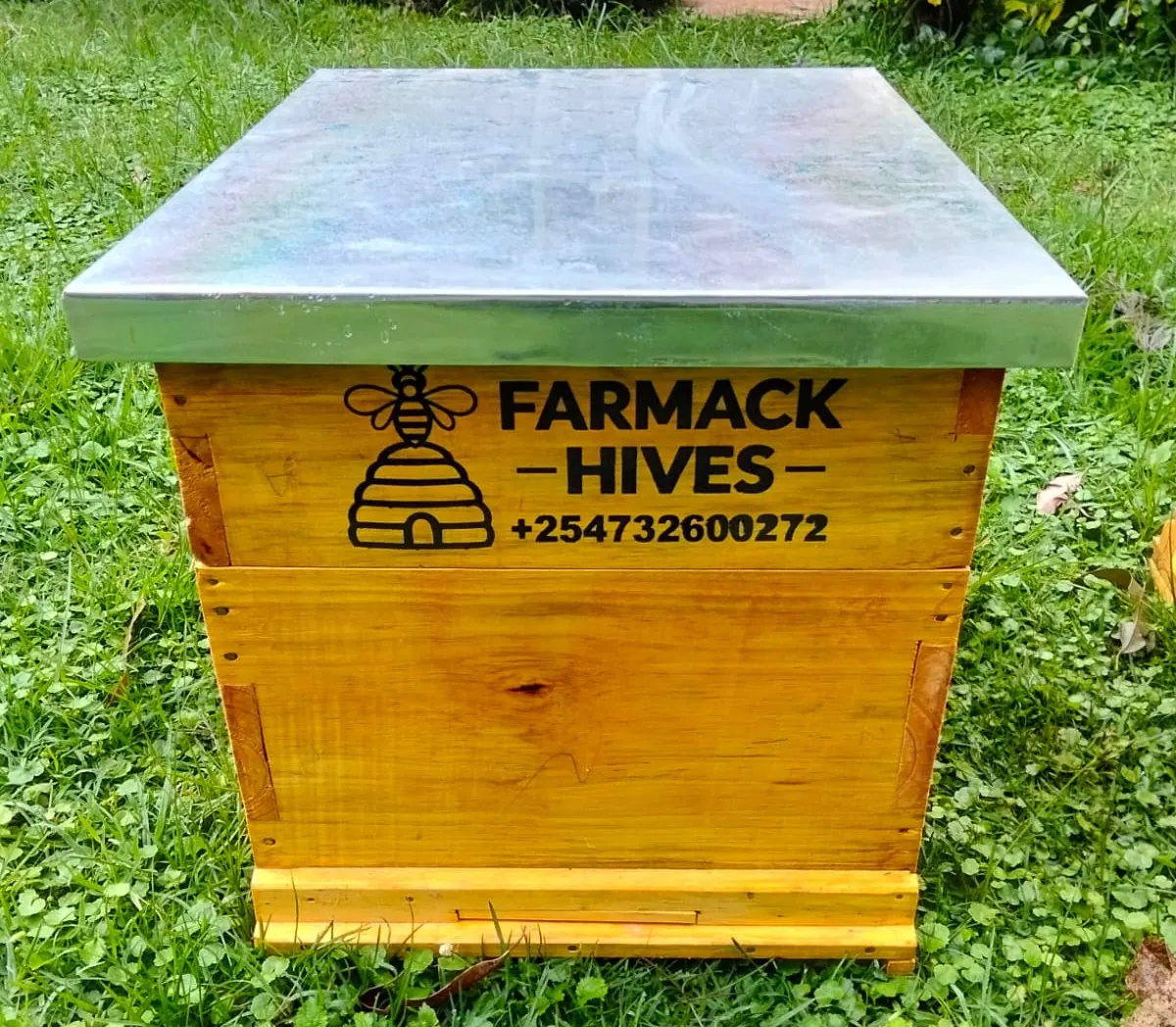 Branded Farmack beehive standing in a green garden apiary